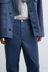 Pantalón de algodón azul marino, de corte recto (straight fit) con cinco bolsillos y cierre frontal de cremallera y botón.