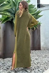Vestido largo de punto en color verde oliva, con diseño de paneles en dos tonos de verde, mangas largas con textura perforada y tajos laterales en el ruedo.