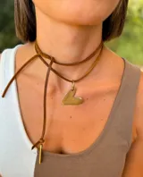 Gargantilla de cordón de cuero marrón con dije de corazón en metal dorado de acabado mate.