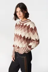 Sweater de punto con diseño de rombos en tonos marrones y beige, cuello redondo y puños anchos con detalle de rayas horizontales.