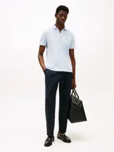 Chomba celeste de piqué de algodón elástico, de corte regular, con cuello tipo polo y cartera de dos botones. Presenta logo de Tommy Hilfiger bordado en el pecho.