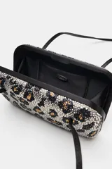 Bolso de hombro formato caja con estampado animal print cubierto de apliques brillantes. Posee doble asa de hombro, bolsillo interior y cierre imantado.