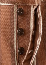 Jeans de corte recto y tiro medio con diseño de rayas verticales en tonos marrón y blanco.