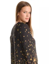 Blusa de gasa con estampado abstracto en tonos amarillos sobre fondo negro. Presenta cuello mao con escote en V y cierre frontal parcial con botones. Las mangas son largas y cuentan con presillas para ajustar su largo.