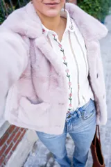 Camisa blanca de algodón con bordados de flores rosas en cuello, frente y puños, corte clásico y cierre con botones.