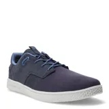 Championes urbanos Caterpillar modelo Pause Canvas, color azul marino con detalles en celeste. Confeccionados en una combinación de lona y gamuza, con suela blanca texturizada y cierre de cordones.