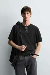 Camiseta de corte relaxed fit, confeccionada en mezcla de algodón y lino, con cuello redondo y mangas cortas.
