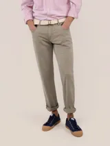 Pantalón de gabardina color gris topo, de corte slim fit, con diseño clásico de cinco bolsillos y cierre frontal de cremallera.