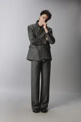Pantalón de traje relaxed fit en color gris oscuro con diseño de espiga. Cuenta con bolsillos frontales, bolsillos traseros de vivo y cierre frontal con cremallera y botón.