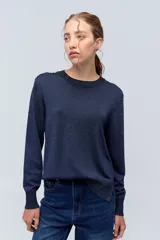 Sweater azul marino de tejido de punto con cuello redondo y mangas largas. Presenta pequeños apliques brillantes en el frente y la espalda.