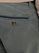 Pantalón chino de corte regular fit, confeccionado en gabardina con acabado desgastado. Presenta bolsillos laterales y traseros, con cierre de botón y cremallera.