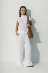 Pantalón blanco de lino, de corte palazzo y cintura con cordón ajustable.