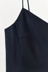 Vestido corto de tejido satinado color azul marino, con escote pico y tirantes finos. El bajo tiene una abertura frontal.