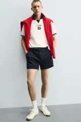 Shorts de corte sastrero confeccionados en tejido de piqué elástico, con cierre frontal de cremallera y gancho metálico oculto, y bolsillos laterales.
