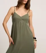 Vestido largo de corte evasé confeccionado en crepé color verde oliva. Presenta escote corazón, breteles finos ajustables, espalda con lastex y tajo lateral en el ruedo.