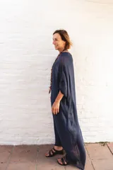 Vestido tipo túnica de corte holgado y fluido, con diseño de doble escote en V tanto en el frente como en la espalda. Presenta mangas amplias y una caída elegante, ideal para un look sofisticado y cómodo.