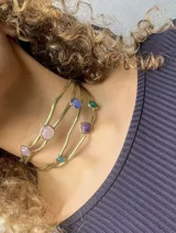 Gargantilla artesanal con cuatro hilos de bronce y alpaca, adornada con piedras de diferentes colores y formas.