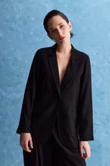 Blazer negro de corte relajado, con solapa clásica y cierre frontal.