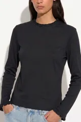 Remera de manga larga color negro, con cuello redondo y puños decorados con volados sutiles.