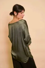 Blusa holgada de satén color beige, con escote en V y mangas largas con trabilla para sujetar remangadas.