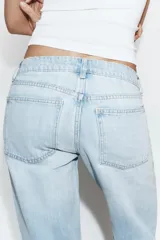 Jeans de tiro bajo y cinco bolsillos, de pierna ancha y larga. Cuenta con cierre frontal con cremallera y botón metálico.