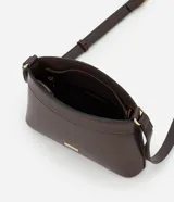 Bolsa bandolera de estructura firme en color marrón oscuro, con cierre de cremallera metálica y correa larga ajustable con hebilla.