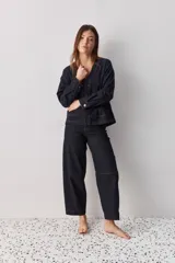 Jean de corte barrel, tiro alto, con silueta amplia que se estrecha hacia el tobillo. Confeccionado en denim azul oscuro con costuras a contratono.