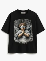 Remera negra de algodón de corte boxy, con estampa frontal estilo vintage que muestra un ángel con los ojos vendados rezando y el texto "BOHEMIAN".