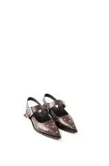 Chatas de cuero negro con punta fina, diseño destalonado y tira con hebilla metálica plateada. Presentan apliques de tachas plateadas en toda la superficie.