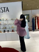 Blusa color rosa viejo, de corte holgado y mangas largas abullonadas.