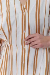Vestido camisero midi con rayas verticales color camel sobre fondo blanco, cuello camisero y mangas 3/4.