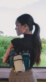 Bolso porta celular con cierre frontal, compartimentos internos para tarjetas y bolsillo trasero. Incluye correa elástica regulable y desmontable.