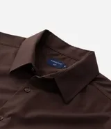 Camisa de corte slim, manga larga, con cuello camisero y cierre frontal de botones. Confeccionada en tejido plano de bambú, viscosa, poliéster y elastano.