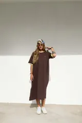 Vestido largo marrón con cuello redondo y mangas cortas con ribete amarillo. Estampado frontal con letras en color crema.