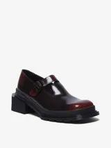 Zapato tipo Mary Jane color bordó brillante con efecto de dos tonos, suela gruesa acanalada negra y tacón cuadrado. Cuenta con una correa ajustable con hebilla sobre el empeine.