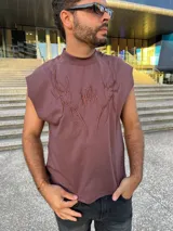 Musculosa marrón con cuello alto y diseño bordado en el frente.