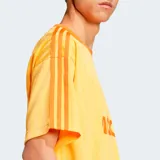 Camiseta Adidas Originals Adicolor naranja con cuello redondo acanalado, logo de Adidas bordado en el pecho, mangas cortas con las tres rayas características de la marca y corte holgado.