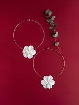 Gargantilla rígida de metal con dije de flor en porcelana blanca.