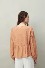 Blusa estampada de caída fluida con cuello redondo y lazos frontales, diseño con cortes horizontales y frunces, mangas largas con puños elastizados.