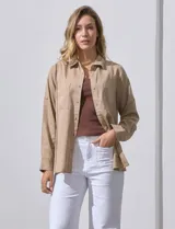 Camisa color beige de lyocell, marca Cyrus. Tiene cuello con solapa, abertura central con botones, mangas largas regulables con presilla y botón, y bolsillos aplicados en la parte delantera.