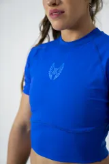 Remera deportiva azul de lycra, corte crop top y mangas cortas.