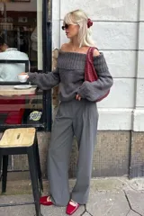 Buzo de punto color gris con diseño off shoulder, escote amplio con borde acanalado, mangas largas y corte relajado.