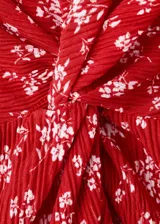 Vestido midi rojo con estampado floral blanco, cuello en V, manga corta y detalle de nudo frontal en el pecho.