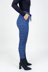 Pantalón de corte recto y tiro medio, confeccionado en tejido jacquard con textura y estampado floral en tonos azul oscuro y negro. Cuenta con bolsillos delanteros funcionales y cintura elastizada.