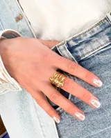 Anillo dorado de acero con diseño abstracto.