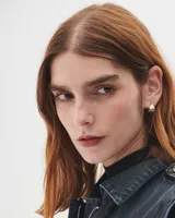 Aros pequeños de bronce con forma irregular y acabado liso, estilo huggie o argolla gruesa.