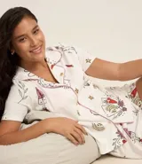 Conjunto de pijama americano corto, compuesto por una camisa de manga corta con cuello solapa y abotonado delantero, y un short con cintura elástica. Estampado con íconos místicos como cartas, corazones y lunas.