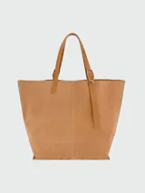 Bolso tote XL Longchamp modelo Complice Softy, confeccionado en gamuza marrón claro con detalle frontal ovalado y asas de cuero liso en tono tostado.