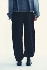 Pantalón de felpa de tiro alto con cintura elástica y corte recto. Cuenta con bolsillos laterales ocultos en la costura y bajo ajustable con cordón elástico y stoppers.