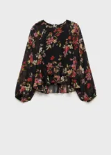Blusa negra semitransparente con estampado floral en tonos rojos y rosas, volantes en el bajo, cuello redondo, manga larga abullonada y cierre de lazo en el cuello.